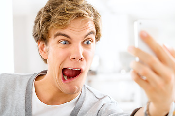 Image showing Life is long be silly. a young woman making funny faces while taking selfies with his smartphone.