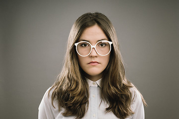 Image showing Always underestimated as a woman. a young woman wearing retro glasses against a studio background.