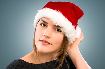 Image showing Christmas has come early. a young woman wearing a christmas hat against a studio background.