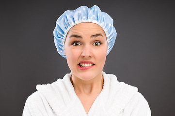 Image showing Time for the morning routine. a young woman about to shower against a studio background.