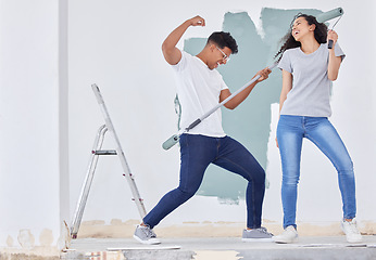 Image showing Lets rock and roll with the renovations. a young couple dancing while busy painting a room.