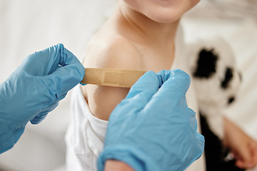 Image showing Innocent curiosity. an unrecognizable doctor applying a cotton ball to a patients arm at home.