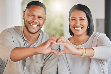 Image showing We were meant to be one. Portrait of a young couple making a heart shape with their hands at home.