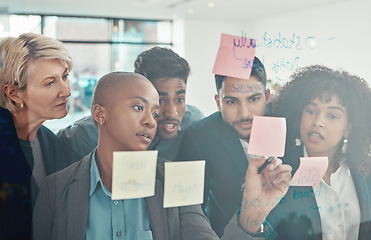 Image showing Lets work on this one right here. a diverse group of businesspeople standing together in the office and using a visual aid to brainstorm.