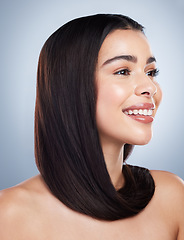 Image showing Beautiful brunette woman with healthy skin and hair against a grey background. Young mixed race woman with long brown hair smiling and looking at the camera