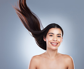 Image showing Portrait of a beautiful brunette woman with flawless skin and healthy hair. Young girl with long brown hair flying in the wind against a studio background