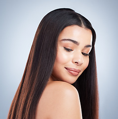 Image showing Beautiful young woman with shiny brown and straight long hair. Young girl looking down over her shoulder and enjoying healthy hair