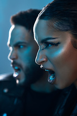 Image showing Theyre serious about fashion. Conceptual shot of a stylish young man and woman posing in studio against a blue background.