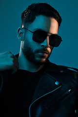 Image showing Cool is always in fashion. Conceptual shot of a stylish young man posing in studio against a blue background.