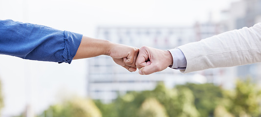 Image showing The way a team works determines its success. two unrecognizable business people fist bumping outside.