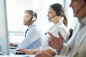 Image showing One of our friendly and experienced agents will be with you now. call center agents wearing headsets while sitting at their computers.