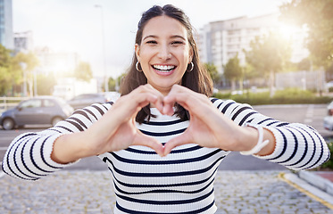 Image showing Love makes the world go round. an young businesswoman making a heart shaped gesture with her hands outside.