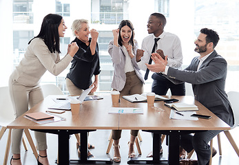 Image showing Every success is a team effort. a group of businesspeople cheering in a meeting at work.