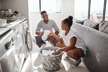 Image showing It doesnt feel tedious when its done with love. a happy young couple doing laundry together at home.