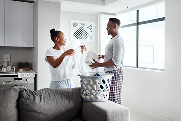 Image showing Keep the mess out of a marriage. a happy young couple doing laundry together at home.