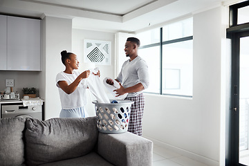 Image showing Sharing the laundry makes more time for quality time. a happy young couple doing laundry together at home.