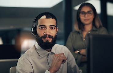 Image showing We mean it when we say were available 247. Portrait of a call centre agent working in an office alongside a colleague at night.