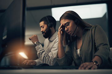 Image showing Some customers are just a pain to deal with. a call centre agent looking stressed out while working in an office at night.