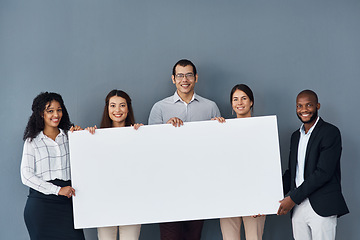 Image showing Well show everyone your message. Portrait of a group of businesspeople holding a black poster while standing against a grey background.