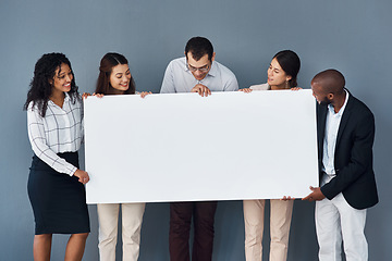 Image showing How you brand your business definitely matters a lot. Portrait of a group of businesspeople holding a black poster while standing against a grey background.