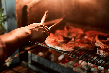 Image showing The grill master knows what hes doing. Closeup shot of an unrecognisable man grilling meat while having a barbecue.