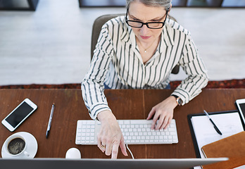 Image showing Driving dedication into achieving results. High angle shot of a mature businesswoman working on a computer in an office.