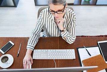 Image showing Putting in the time and effort to achieve results. High angle shot of a mature businesswoman working on a computer in an office.