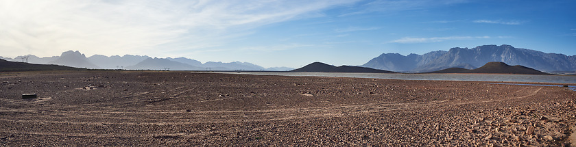 Image showing Water saves lives. a desolate landscape during the day with a small dried out dam in the middle.