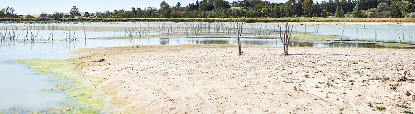 Image showing We need to stop this from happening. a desolate landscape during the day with a small dried out dam in the middle.