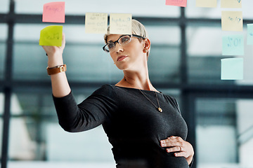 Image showing Making plans for the future of her business. a pregnant businesswoman brainstorming with notes on a glass wall in an office.