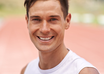 Image showing Life is about doing what you love. Portrait of a happy handsome athlete standing on the track.