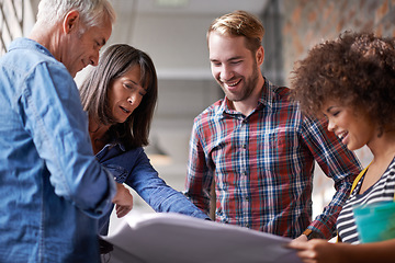 Image showing Making surprise discoveries along the way. A group of colleagues standing in a building and assessing blueprints.