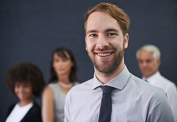 Image showing Teamwork divides the task and multiplies success. a young professional man standing in front of a group of coworkers.