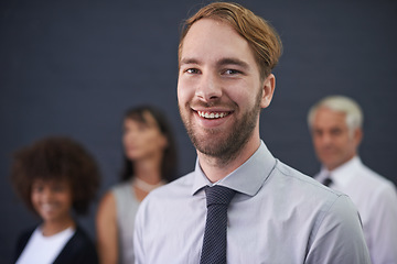 Image showing Ive got the best team behind me. a young professional man standing in front of a group of coworkers.