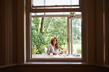 Image showing Searching for inspiration in the summer sun. an attractive young woman writing in a relaxed environment outdoors.