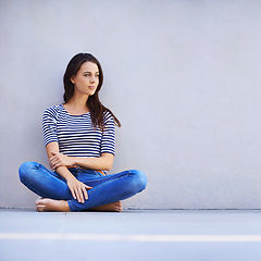 Image showing Free to be myself. Full length shot of a beautiful young woman sitting on the floor.
