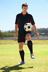Image showing He can keep this ball in the air for hours. a young footballer bouncing a ball on his knee.