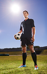 Image showing In the spotlight. a young footballer standing on a field with a ball in his hands.