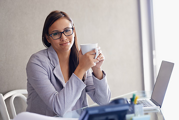 Image showing Its important to take breaks at the office. An attractive young businesswoman drinking coffee while sitting at her desk.