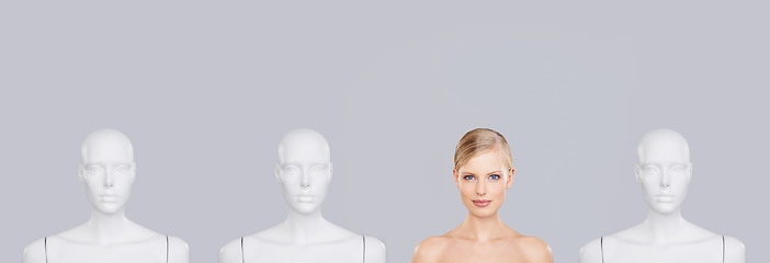 Image showing Dont be another face in the crowd. A beautiful young woman standing amongst a row of mannequins.