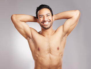 Image showing Handsome young mixed race man shirtless in studio isolated against a grey background. Hispanic well groomed male looking confident and happy with his daily skincare regime. Firm and healthy skin