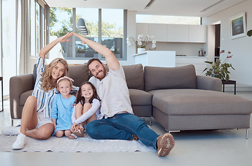 Image showing Happy caucasian couple making symbolic roof with hands above cute little daughters while sitting together on floor in living room. Cheerful family in their new home