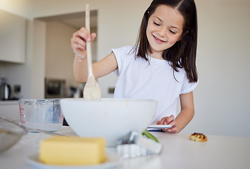 Image showing Happy little girl baking at home. Smart girl mixing ingredients to prepare dough in the kitchen. Helpful child in the kitchen