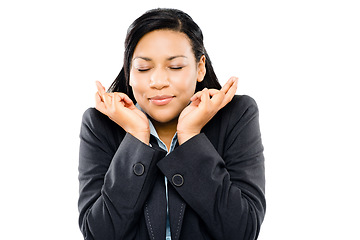 Image showing Make a wish on a star. a young businesswoman crossing her fingers in hope against a studio background.