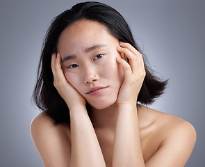 Image showing Can you tell how bored I am. a young woman standing against a grey background.