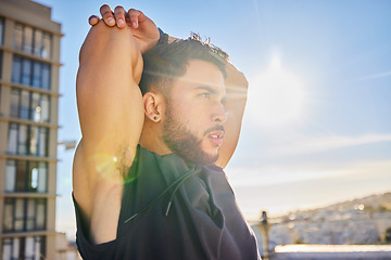 Image showing First things first, you have to change your mindset. a sporty young man stretching while on a rooftop.