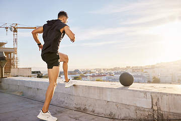 Image showing You dont need fancy machinery to get a good workout. a sporty young man out on a rooftop for a workout.