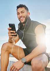 Image showing Once I open my music player, the timer starts. a man wearing earphones while sitting outside in exercise clothes.