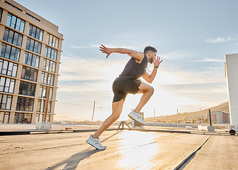 Image showing Create good habits and achieve your goals. a sporty young man out on a rooftop for a workout.