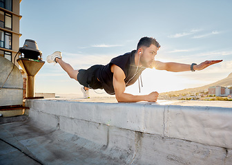 Image showing Move outside your comfort zone if you want to achieve greatness. a man doing a single-arm plank while on a rooftop.